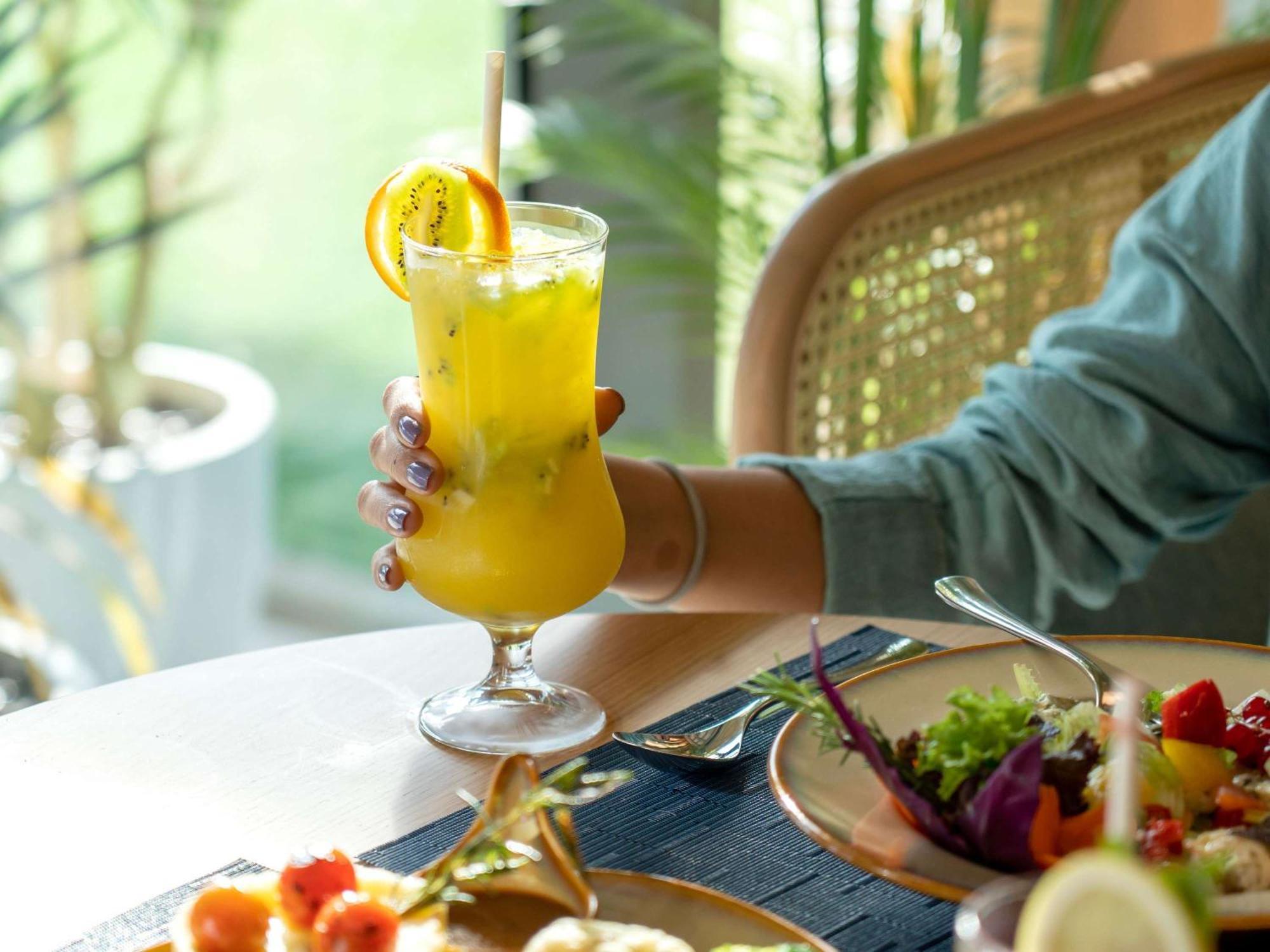 Swissotel Living Джедда Экстерьер фото A woman holding a glass of juice